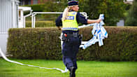 Poliisi vatää eristysnauhaa rikospaikalla.
