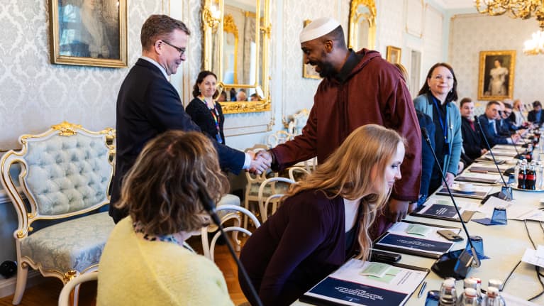 Orpo kättelee Myyrmäen sunnilaisen As-Salam-moskeijan imaami Sharmarke Said Aw-Mussea.