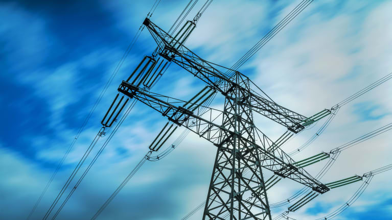 En elstolpe fotograferad mot en dramatiskt mörkblå himmel. 