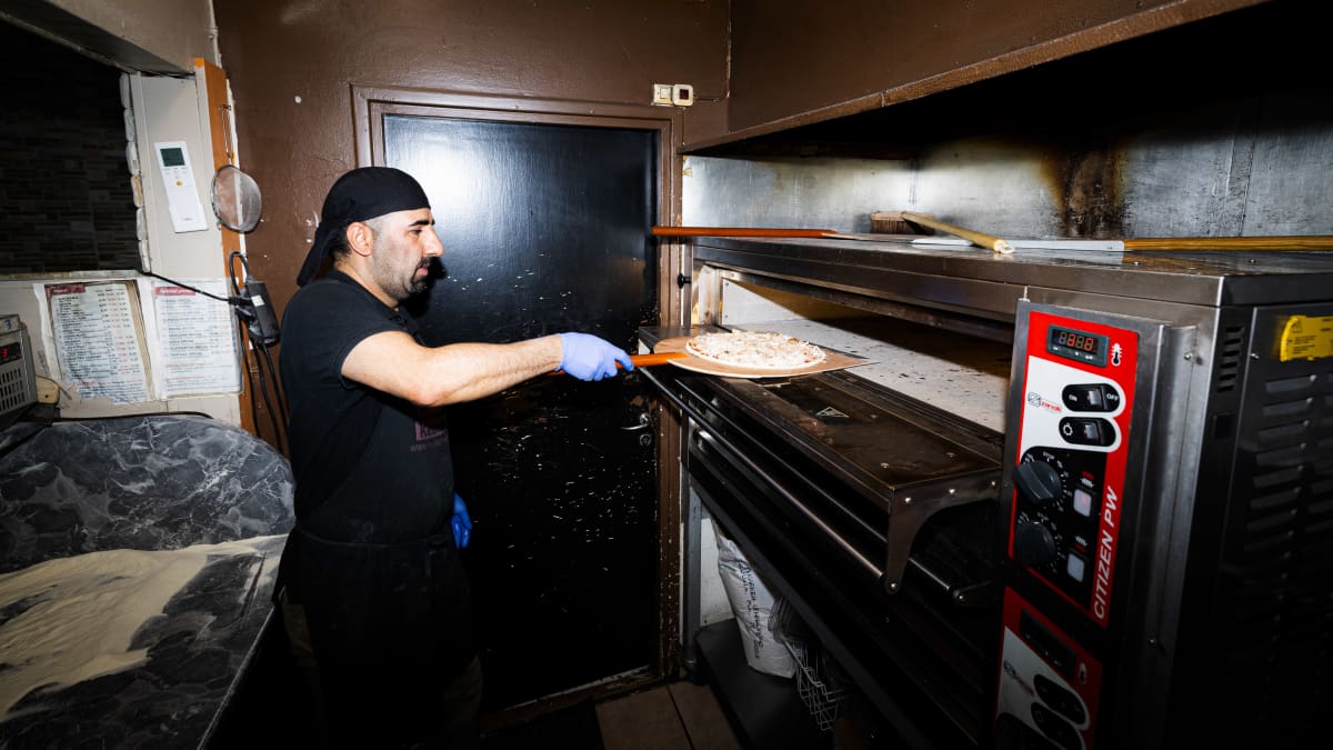 Pizzeria Halssilan Aito Dönerin yrittäjä Omid Maghsoudi valmistamassa pitsaa.