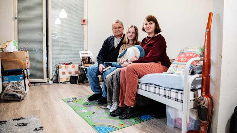 Isä Yurii Liashchevskyi, tytär Viktoriia ja äiti Oksana Liashchevska asuvat vastaanottokeskuksessa Espoossa. Kuva: Silja Viitala / Yle