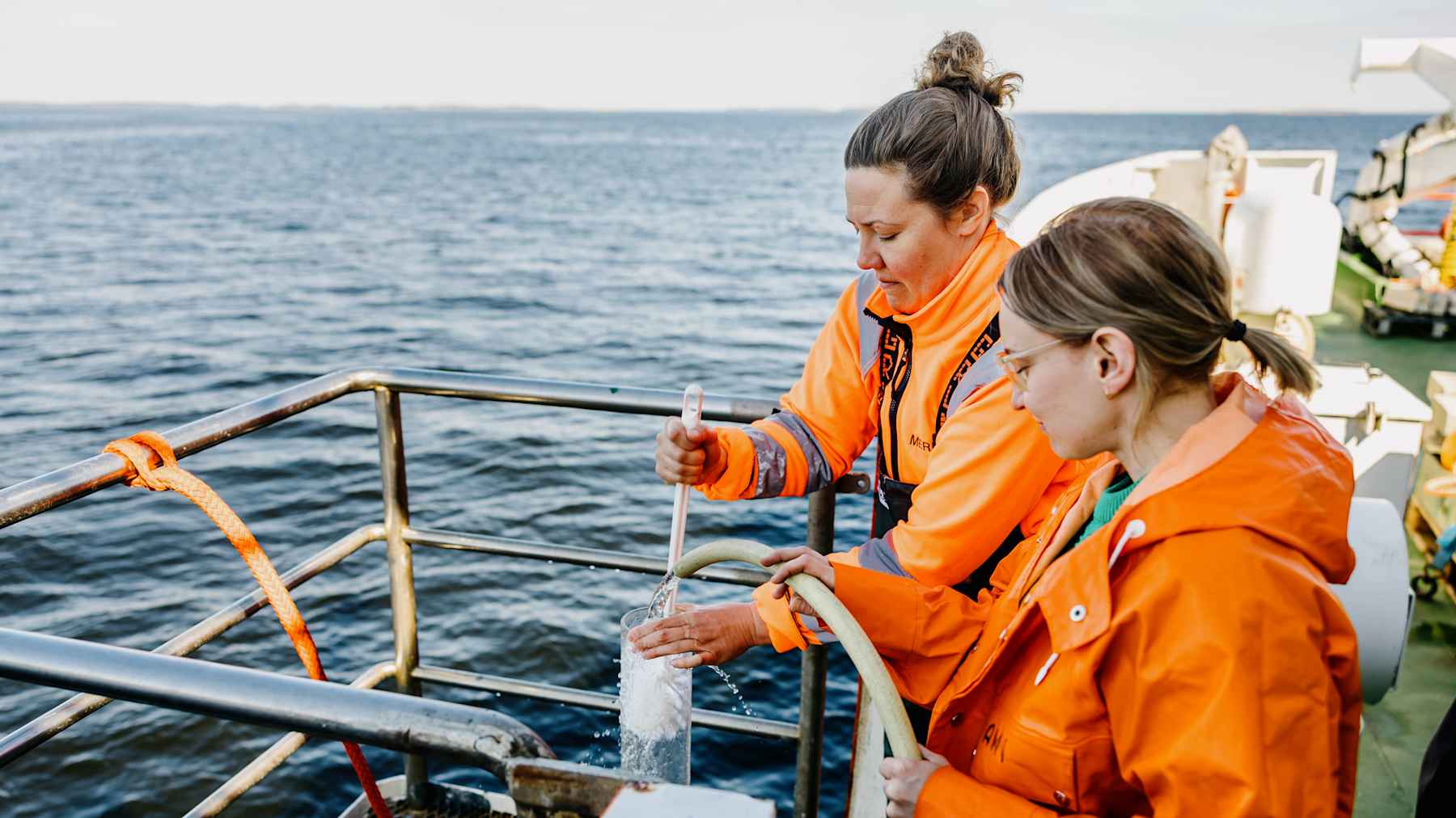 Kaksi henkilöä pesevät tutkimuskalustoa.