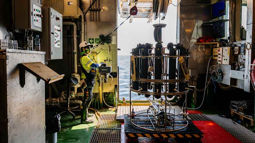 Meritutkija valmistautuu laskemaan merentutkimuslaitteen mereen.