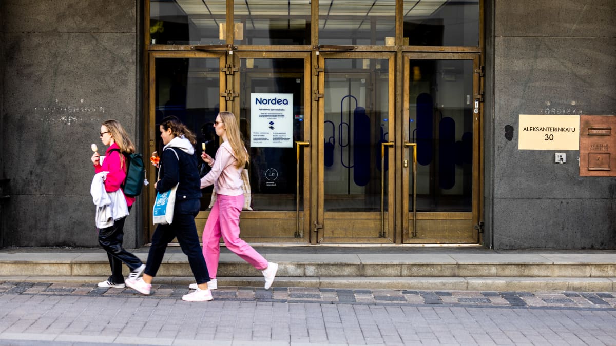 Young people outside a branch of Nordea bank. 