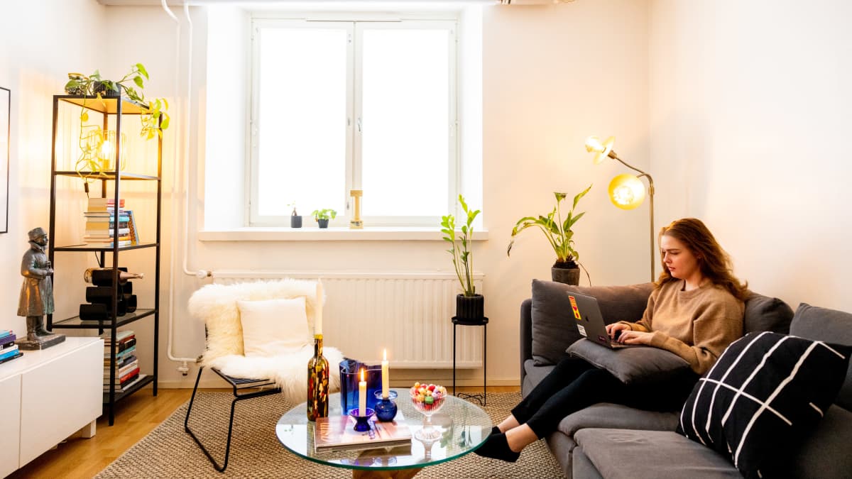  Joanna Lybeck istuu työhuoneellaan sohvalla kannettava tietokone sylissään.