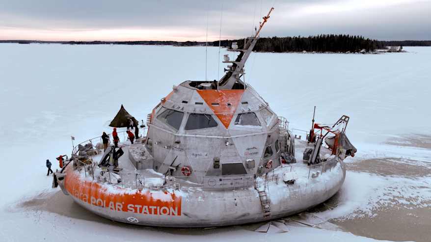 Jäällä on valko-oranssi tutkimusalus, jonka kannella seisoo ihmisiä työssä.