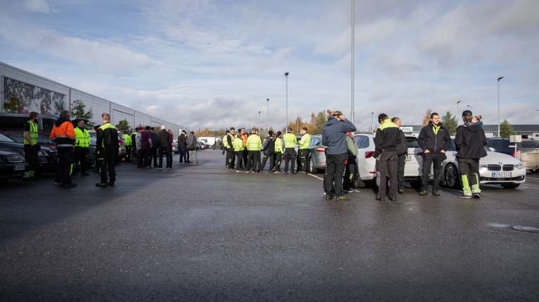 BRP Finlandin pihalla vaja viitisenkymmentä ihmistä ulosmarssimassa.