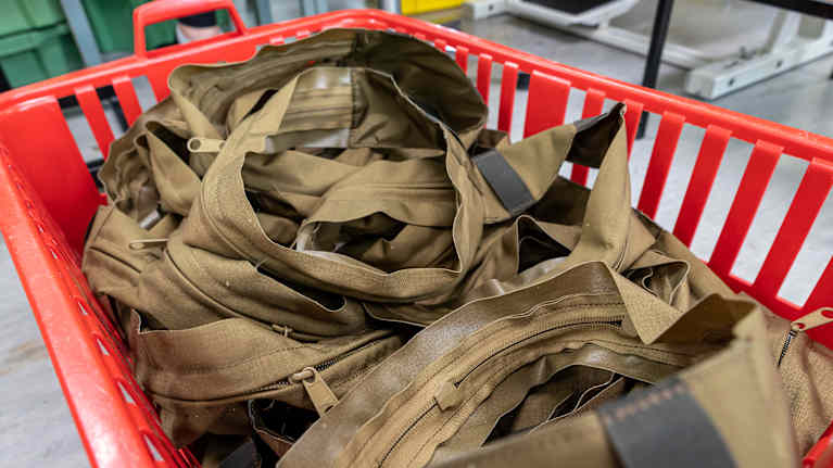 Finn-Savotta Oy:n Karstulan ompelimo. Ompelupisteeltä tulleita valmiita tuotteita korissa.