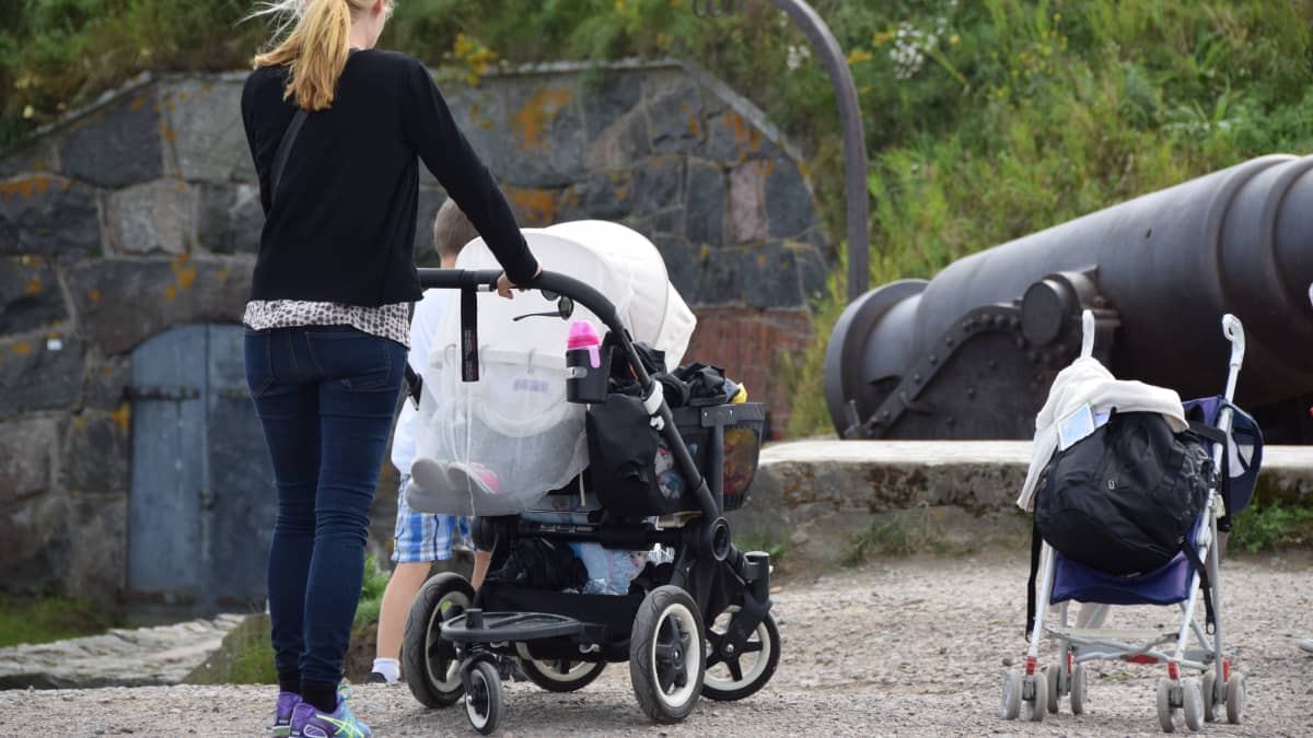 mamma med små barn intill gamla kanoner på Sveaborg.