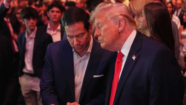 Mies näyttää toiselle jotain kännykän ruudulta.