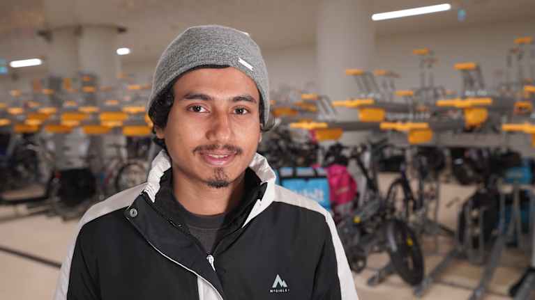 Wolt-kuljettaja Nahid Islam,  6 kk Woltilla,  seisoo polkupyöräsuojassa Helsingin rautatieasemalla kameraan katsoen.