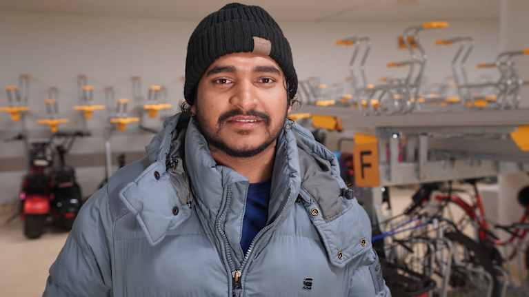 Wolt-kuljettaja Md. Rakib Mia Bangladeshista,  6 kk Woltilla, seisoo Polkupyöräsuojassa Helsingin rautatieasemalla kameraan katsoen.