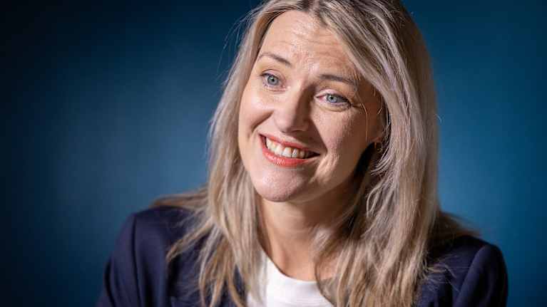 Eira Roos is sitting at a white table.