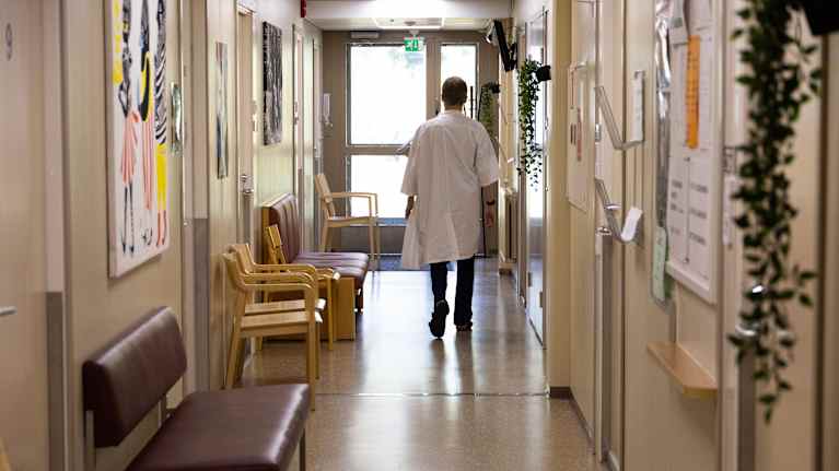 Lääkäri Aleksi Ahola käveleämssä Haminan terveyskeskuksen käytävällä.