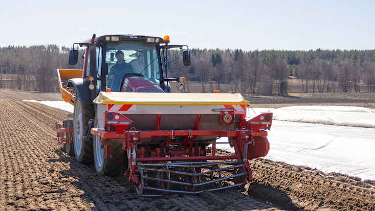 En traktor körs på en åker och utför jordbruksarbete.