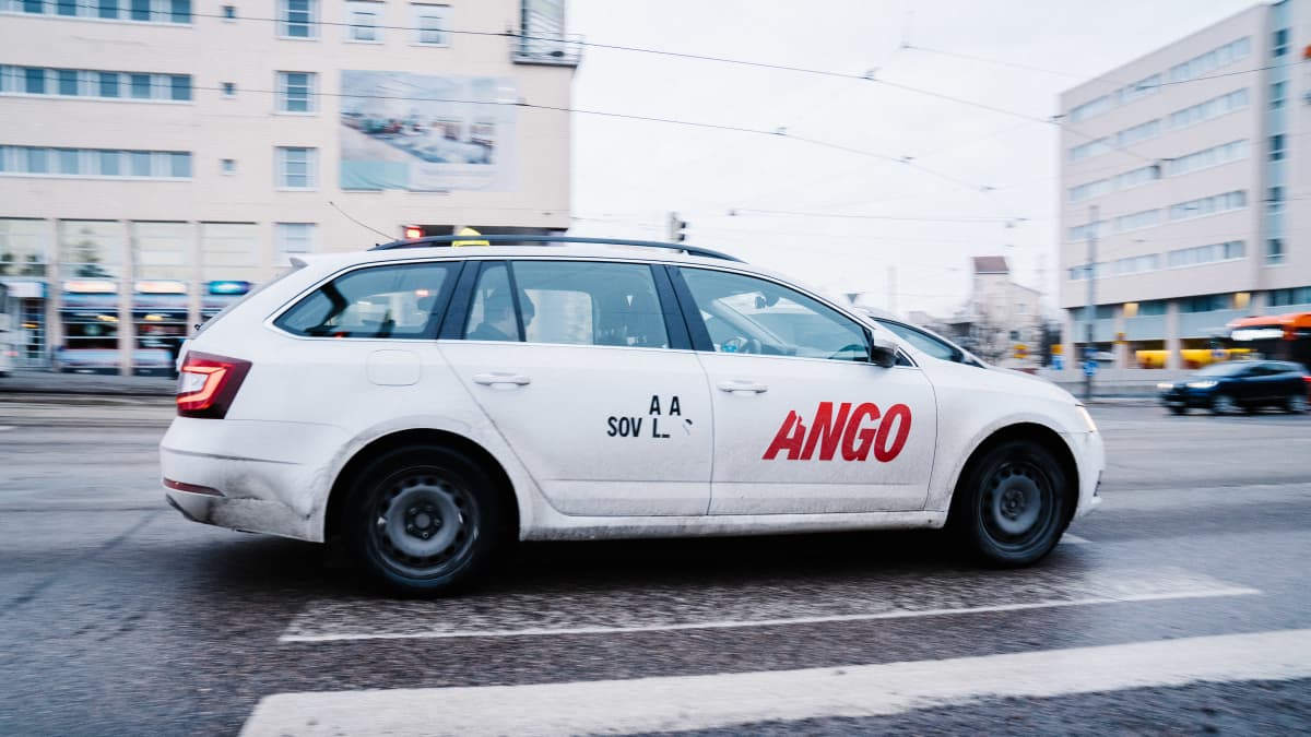 Taksiyhtiö Yangon auto Helsingissä Ruskeasuolla. Auton kyljen teippaukset osittain irronneet.