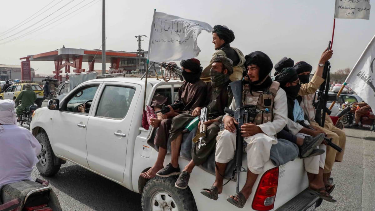 Joukko taliban-taistelijoita valkoisen avolava-auton lavalla 17. elokuuta 2021.