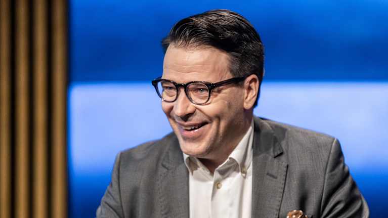 Europaparlamentariker Ville Niinistö skrattar i Yles studio.