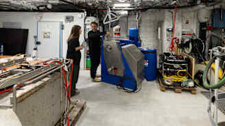 Kaksi ihmistä tutkii aluksen tutkimuslaitteita.