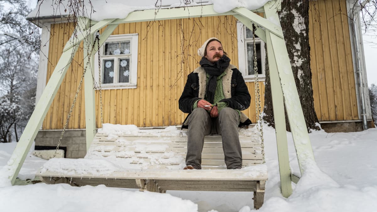 Lassi Valtonen katselee mietteliäänä ja istuu keinussa