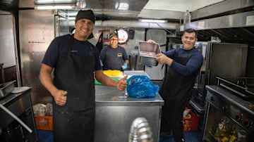 The ship's kitchen, with staff taking a group photo. 