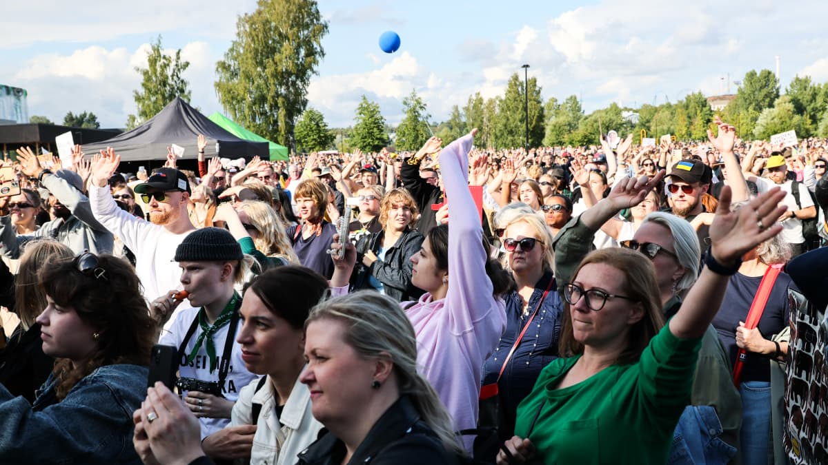Mielenosoittajat kuuntelemassa esiintyjiä Töölönlahden tapahtumapuistossa.
