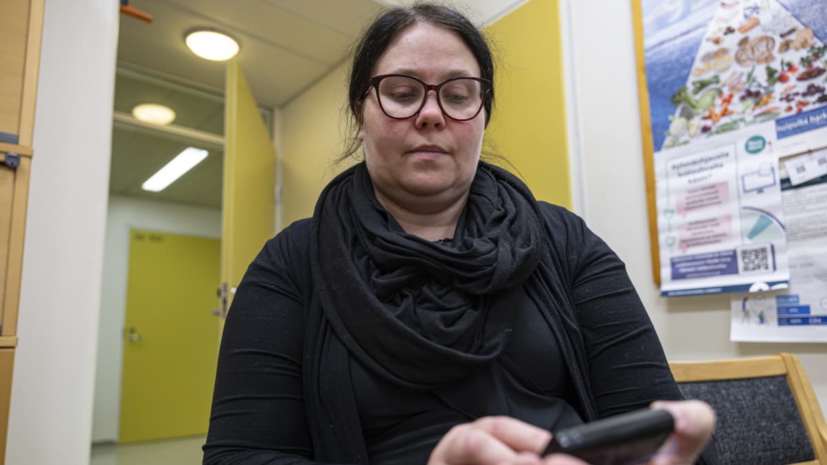 Hanna Horma pitää kädessään insuliinipumppua.