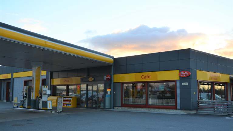 Servicestation med café innuti och tankstation utanför
