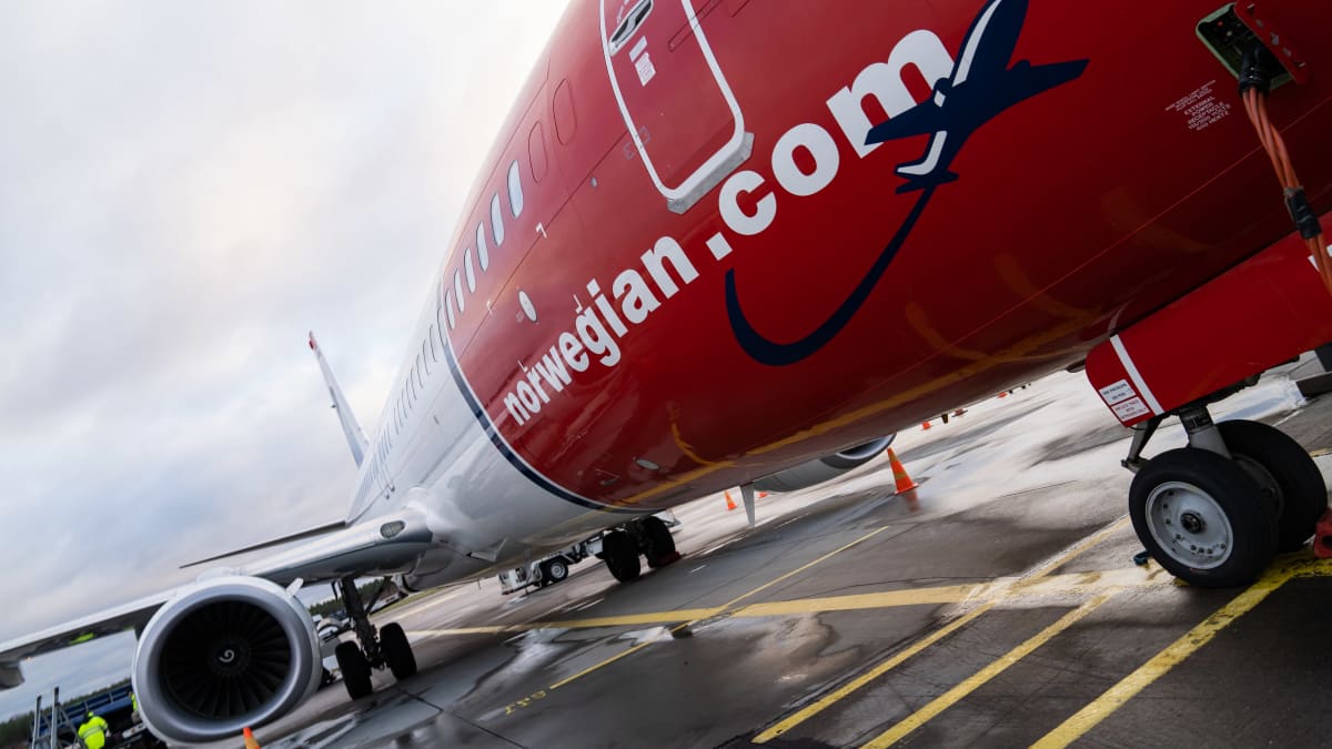 yleiskuva - Norwegian -halpalentoyhtiön kone lentokentällä odottamassa matkustajia.