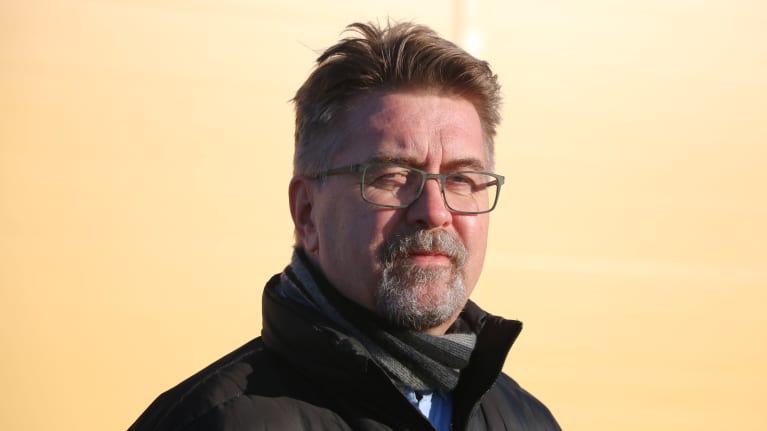 En skäggig man med glasögon.