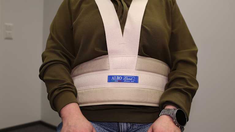 Posture belt attached to a person and a chair. A posture belt is a device that restricts the movement of the elderly.