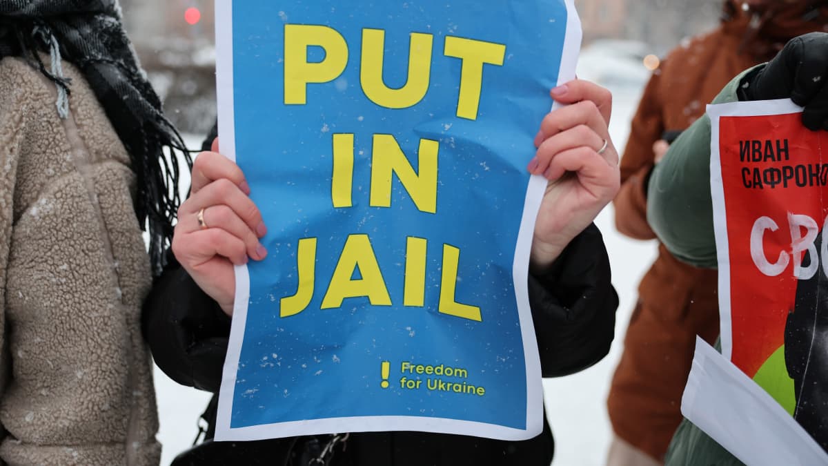 Mielenosoittajan lapussa vaaditaan laittamaan Putin vankilaan.