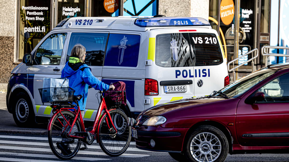 Poliisin ajoneuvo ja sivullisia.