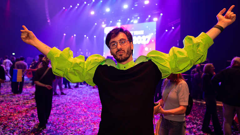 Mies tuulettaa vihreä bolero päällään.