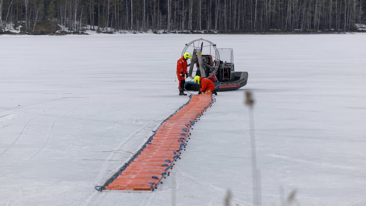 Pelastulaitoksen työntekijät siirtävät öljyntorjuntapuomia ilmatyynyaluksella jäällä Viljakanlahdella Joutsenossa.