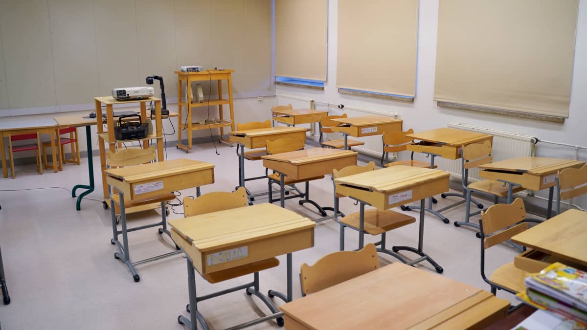 Koululuokka, jossa on tuoleja ja pulpetteja