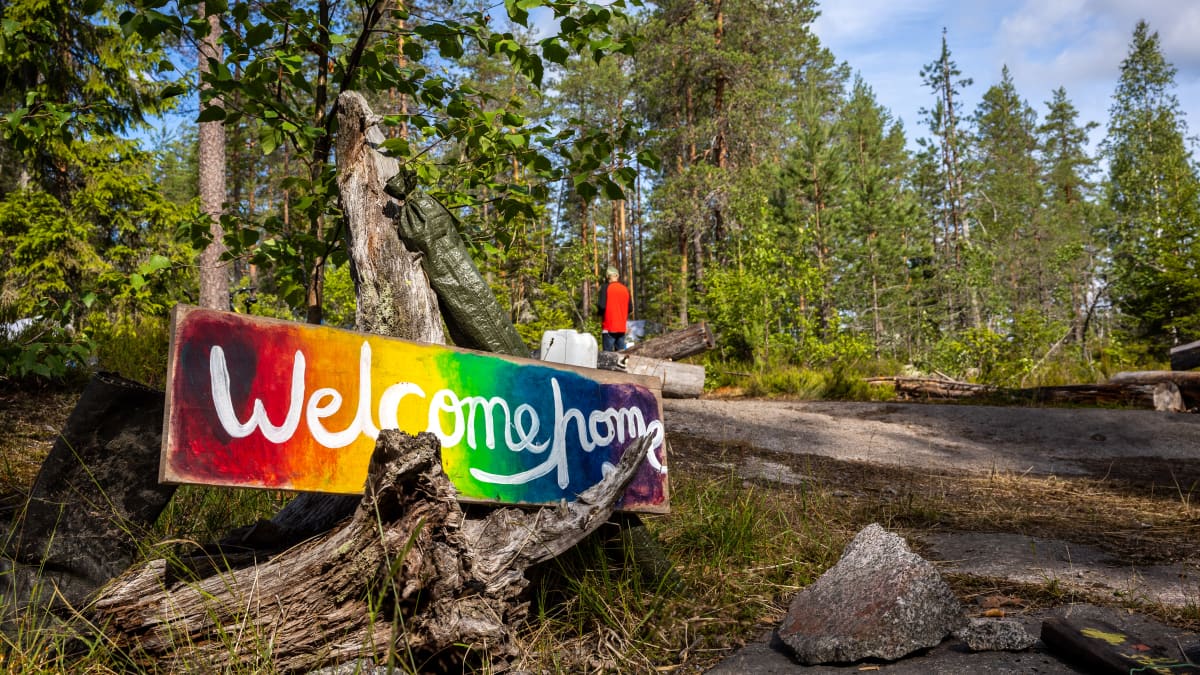 Welcome home -kyltti metsänreunassa.