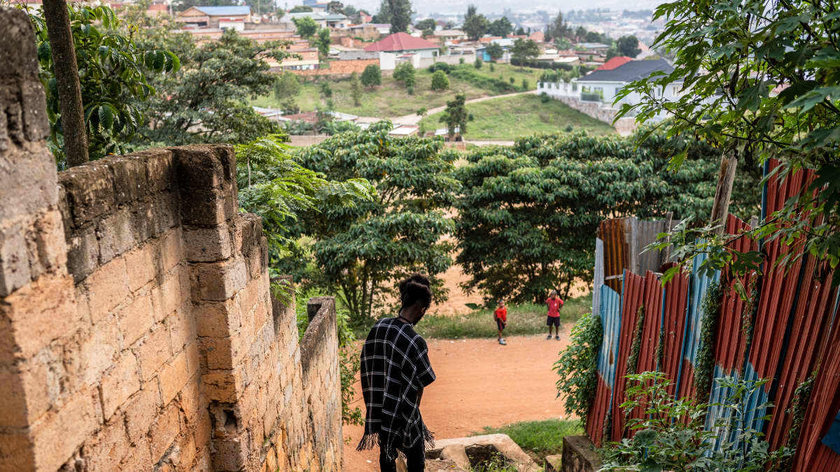 Nuori henkilö kävelee jyrkkiä portaita pitkin, taustalla näkyy vehreä asuinalue.