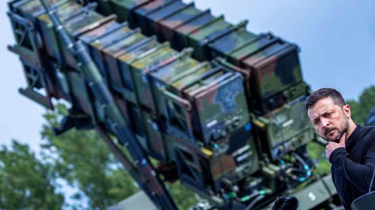 Volodymyr Zelenskyj står bredvid ett Patriot-luftvärnssystem.