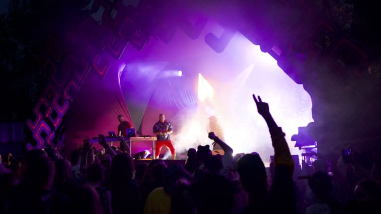 DJ soittaa Kosmos Festivalin lavalla yleisön bilettäessä kädet ilmassa.