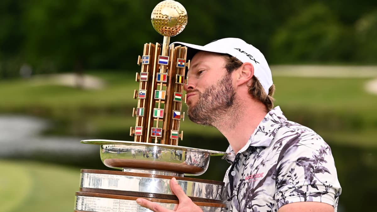 Kalle Samooja pussaa pokaalia golfin Euroopan kiertueella.