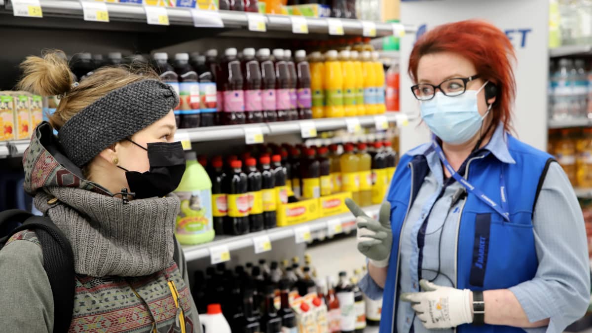 Asiakas ja myyjä juttelevat kaupassa