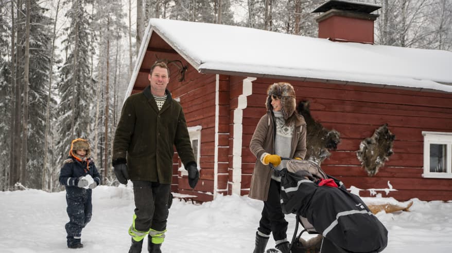 Kinnusen perhe kävelee pihasaunan edessä talvimaisemassa.