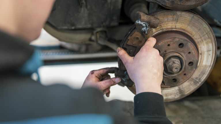 Oppilas vaihtaa autoon jarrupaloja.