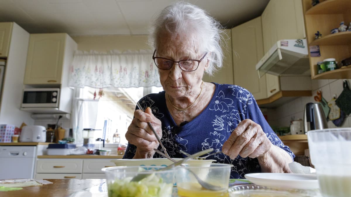 Leena Pulkkinen syö hyvinvointialueen ateriapalveluiden ruokaa omassa keittiössä.