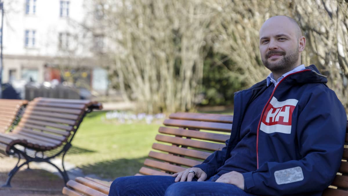 Joonas Könttä istuu puistossa penkillä.