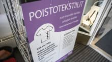 kirjaston tuulikaapissa on tyhjä rullakko, johon voi jättää poistotekstiilejä