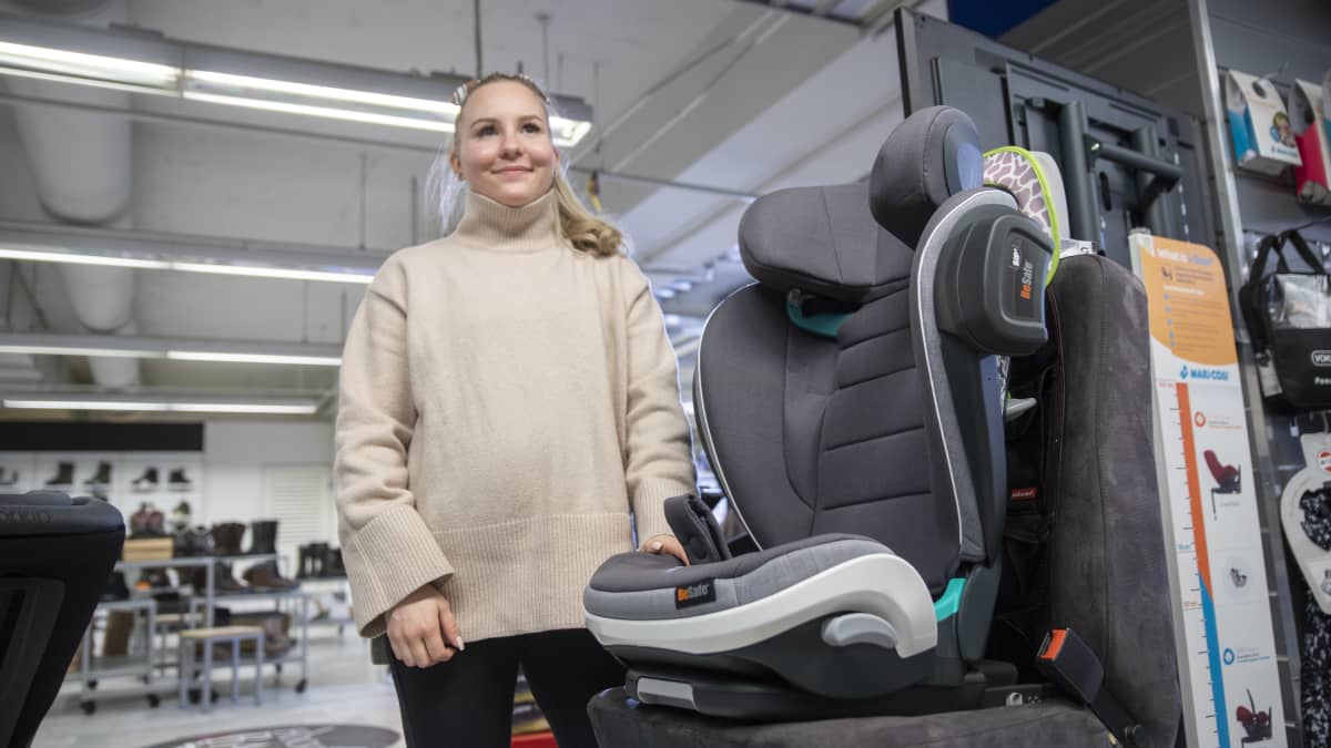 Myyjä esittelee turvaistuinta.