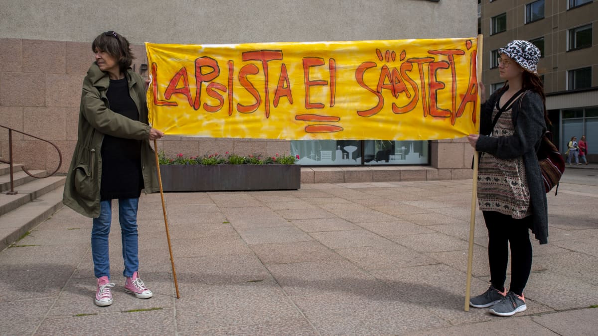 Arja Tauria-Huttunen (vasemmalla) Kotkan kaupungintalon edessä protestoimassa Kotkan koulutusleikkauksia vastaan.