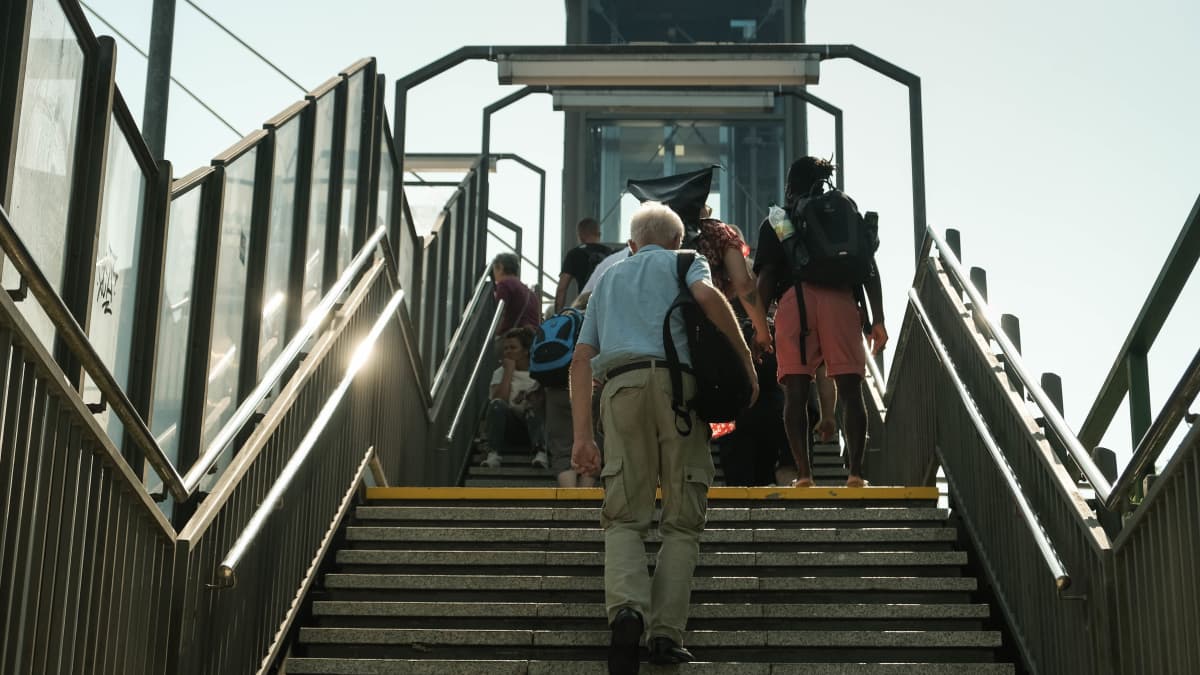 Mies kävelee portaita juna-asemalla